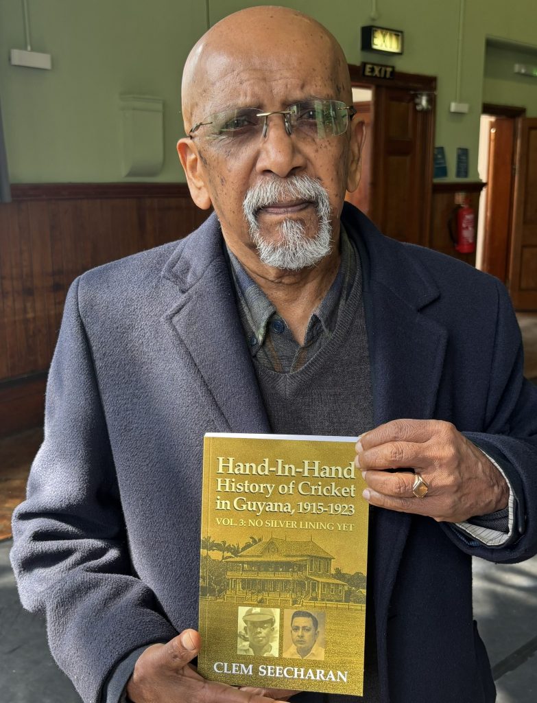 Professor Clem Seecharan with a copy of History of Cricket in Guyana, 1915 to 1923.